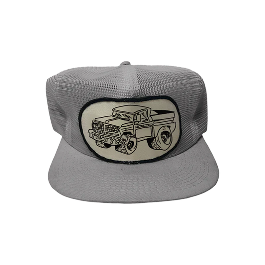 Mesh Trucker Hat front view in grey featuring vintage Posty Co pickup truck patch graphic breathable mesh construction flat brim design and classic Post Malone trucker cap style for everyday wear